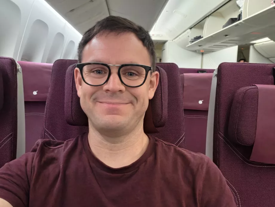 Ja na pokładzie samolotu linii Qatar Airways (moja koszulka pasuje kolorystycznie do wnętrza kabiny!)